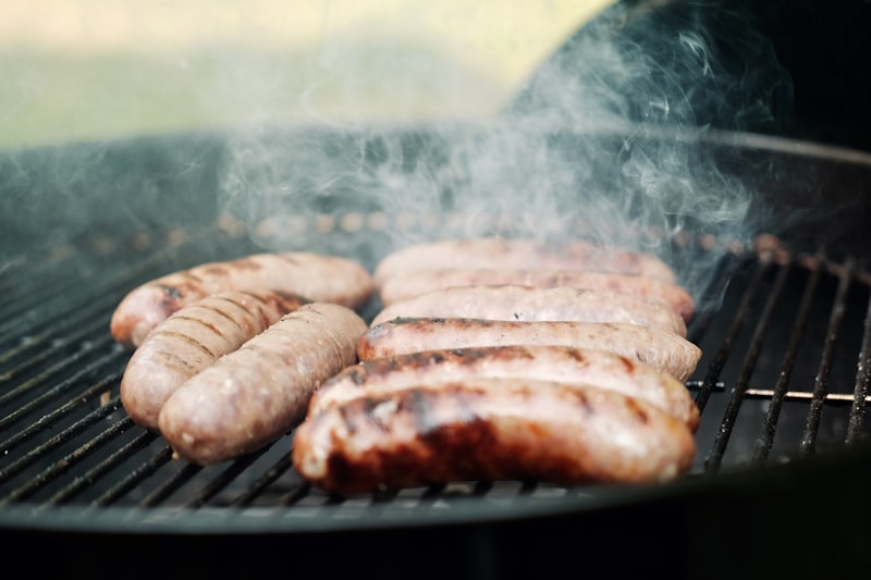 Italian sausage cooking on grill with smoke from unsplash}