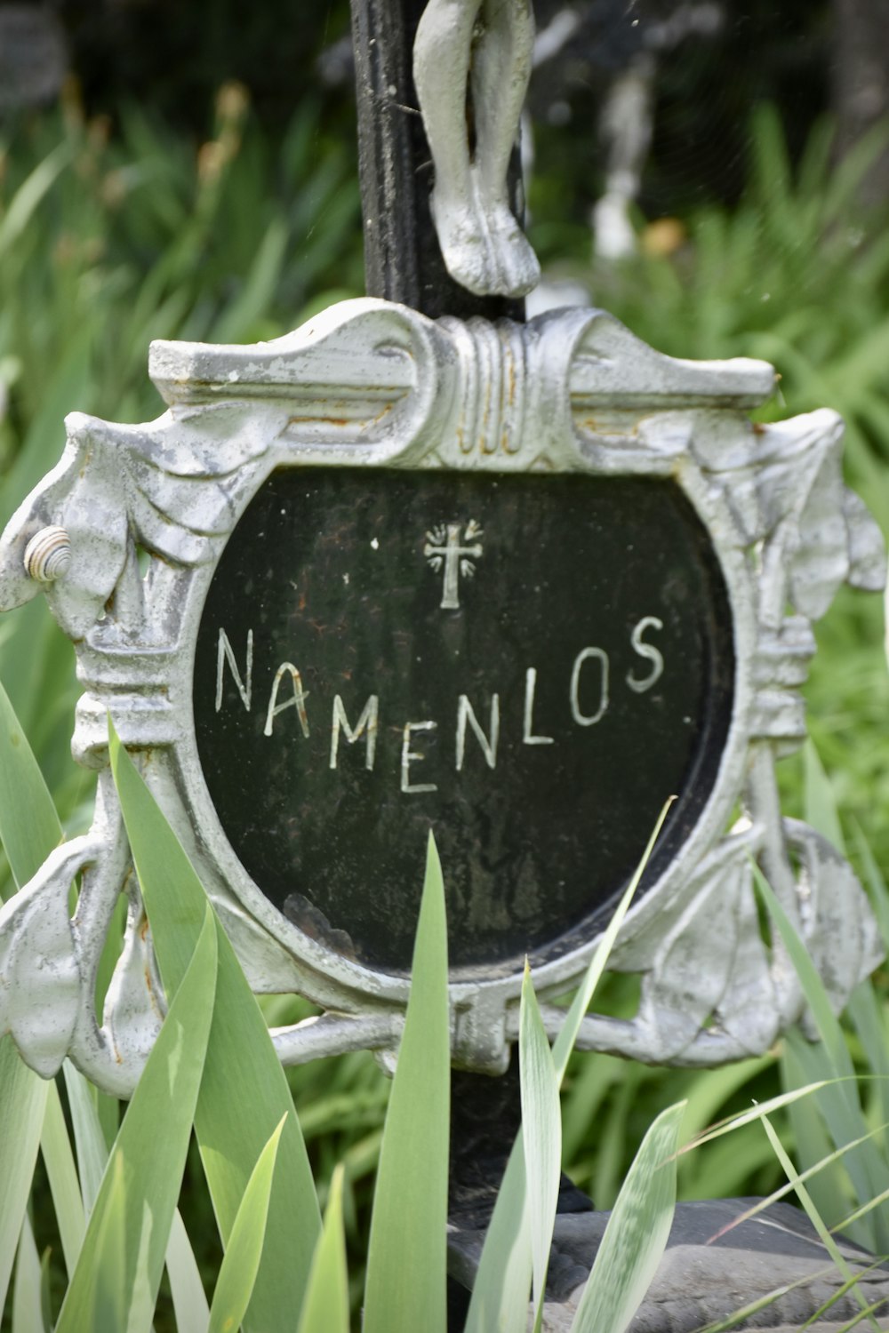 a statue of a man holding a cross in a garden