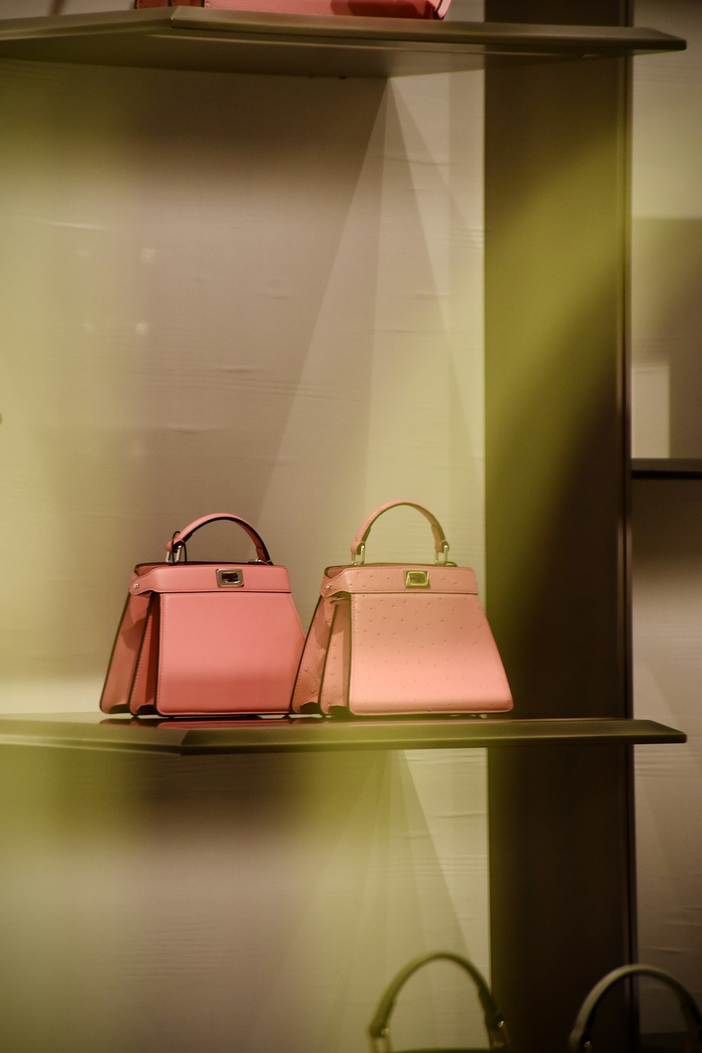 two pink bags are on a shelf in a store