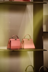 two pink bags are on a shelf in a store