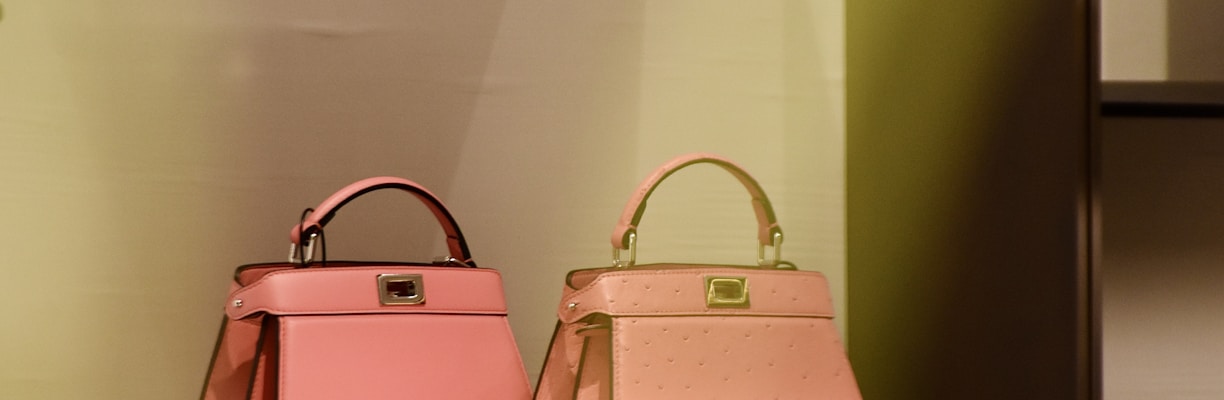 two pink bags are on a shelf in a store