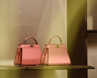 two pink bags are on a shelf in a store