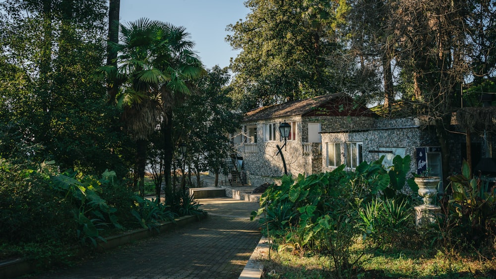 a stone house surrounded by trees on a sunny day