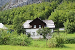 A charming house nestled among trees in Goverdhan, showcasing traditional architecture with a peaceful garden.