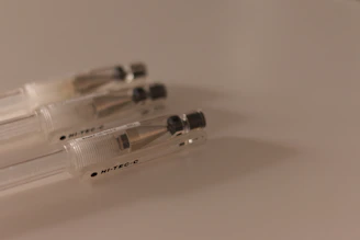 Close-up of smooth, fine-tip pens resting on a light gray textured surface.