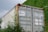 A well-maintained cargo container stored in a lush green environment.