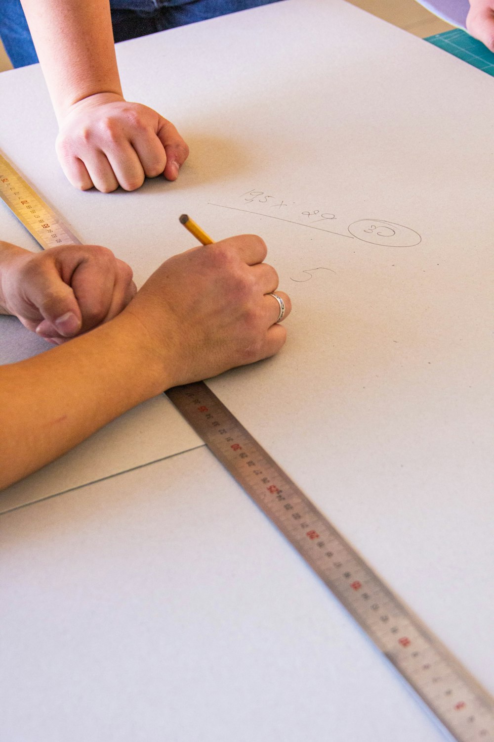 Zwei Personen zeichnen auf einem Blatt Papier