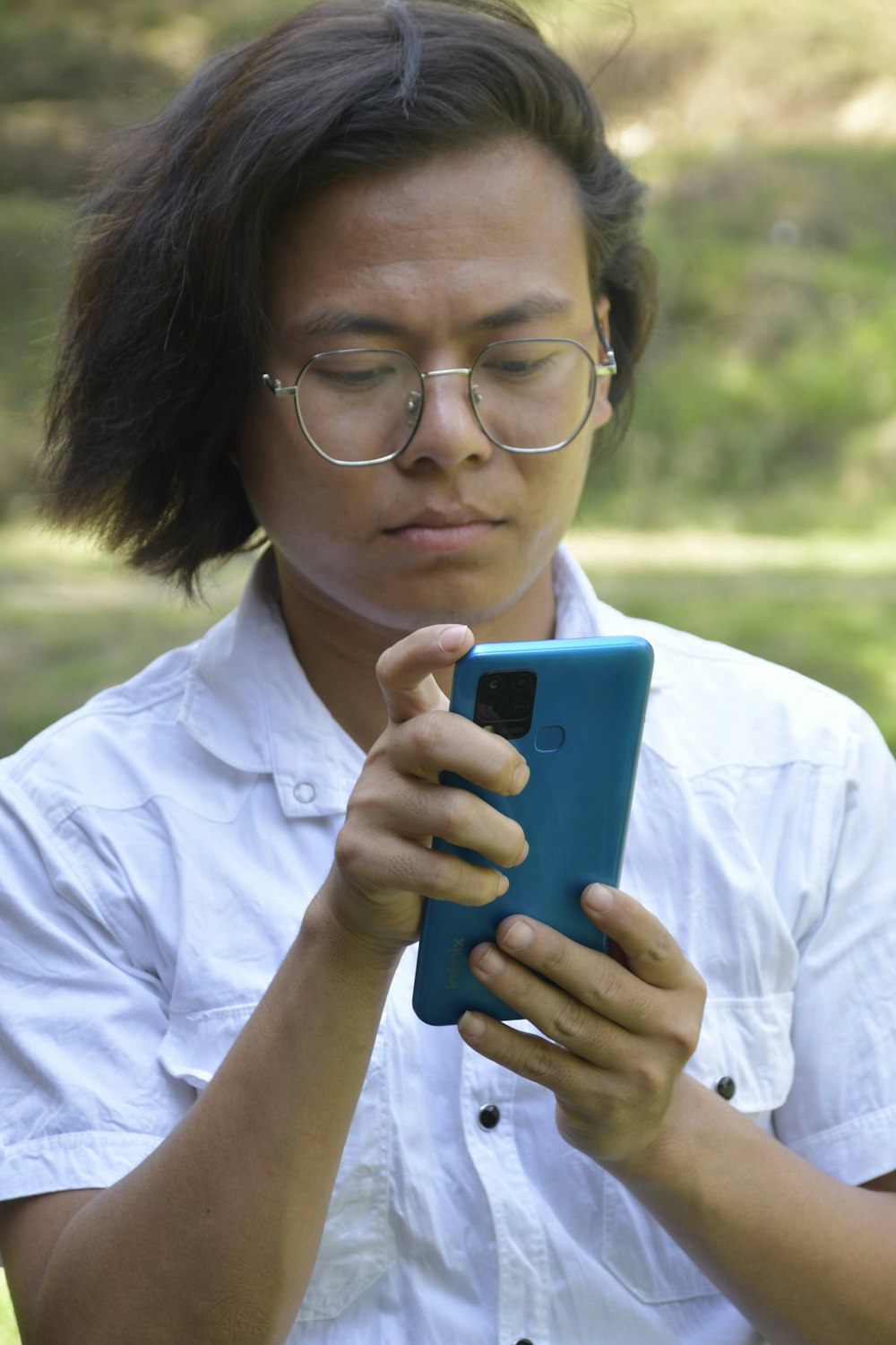 a woman wearing glasses looking at a cell phone