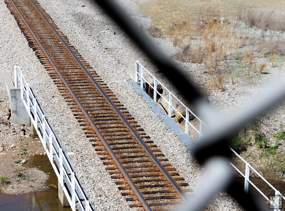 a view of a train track through a fence