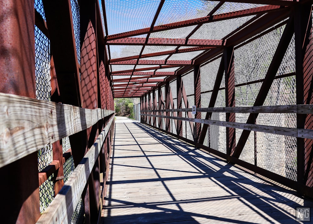 a wooden walkway with a metal fence on top of it