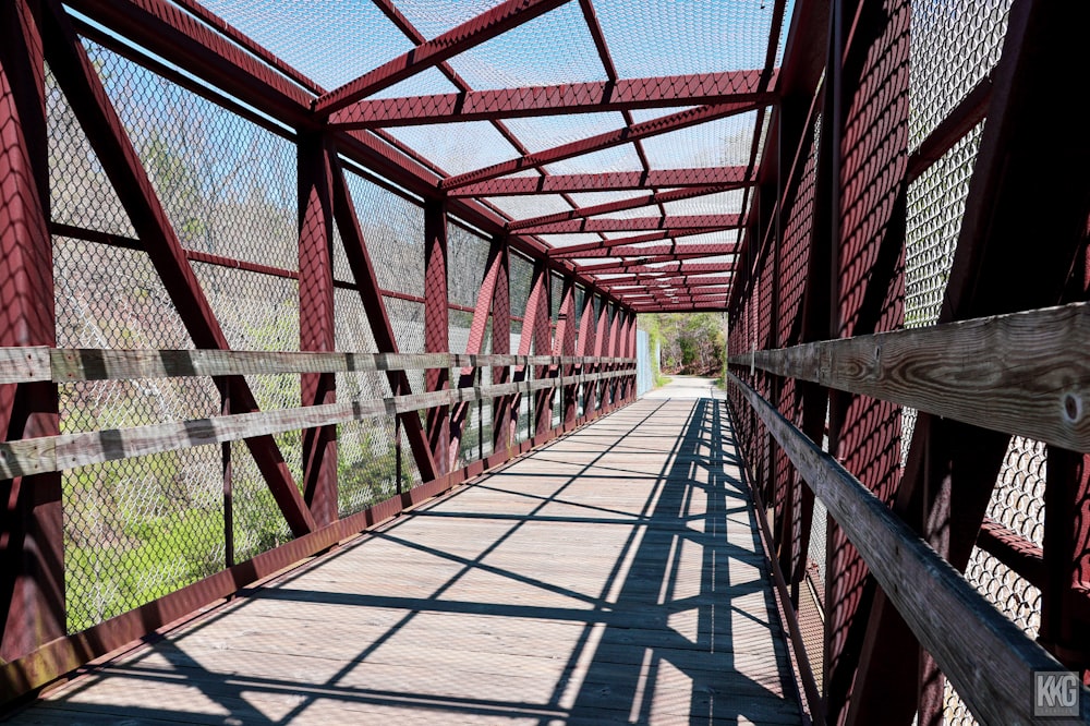 un pont rouge traversé par une passerelle en bois