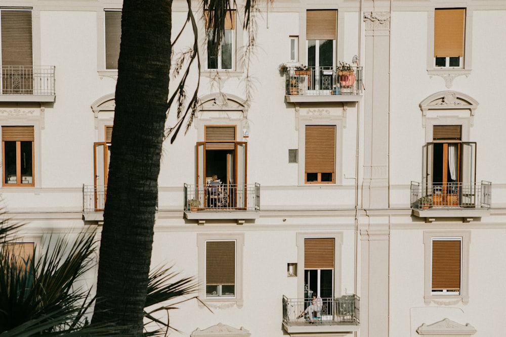 a tall white building with balconies and windows