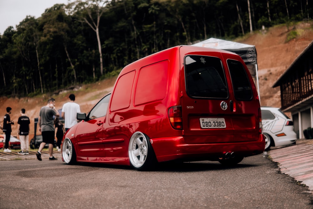 a red van parked in front of a group of people