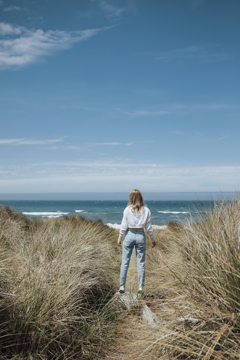 a woman standing on top of a sandy beach