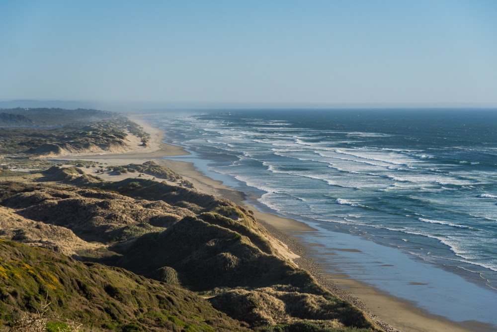 a view of a beach and ocean from the top of a hill