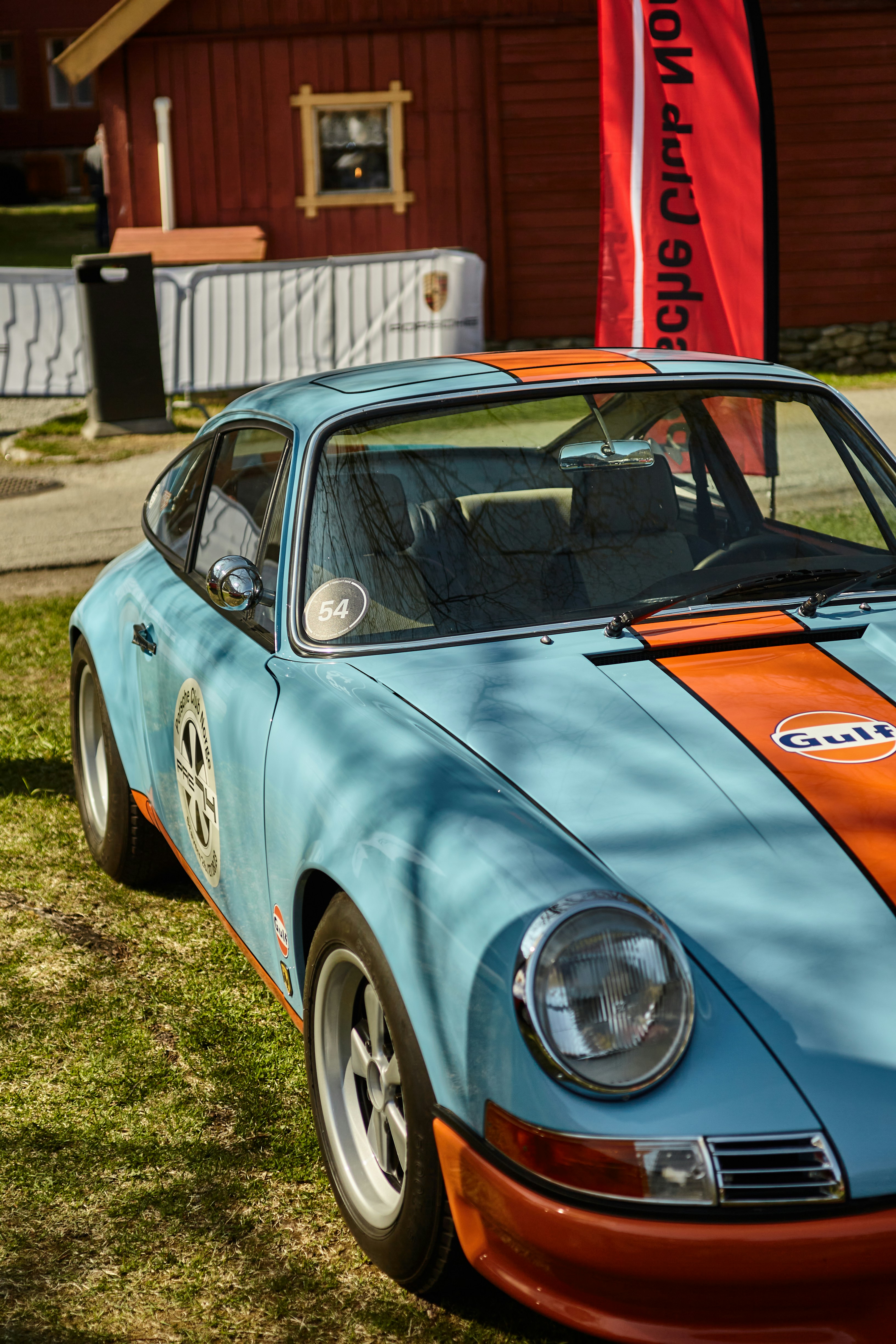 a blue and orange sports car parked in the grass