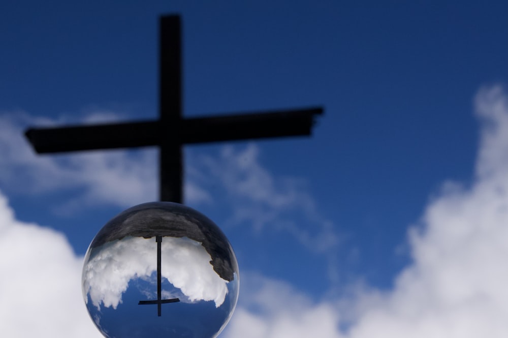 a reflection of a cross in a glass ball