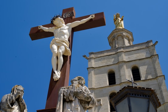 a statue of jesus on a cross next to a church steeple