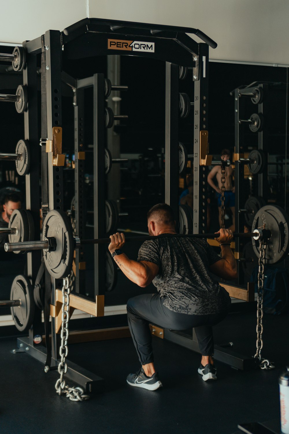 Ein Mann, der in einem Fitnessstudio hockt