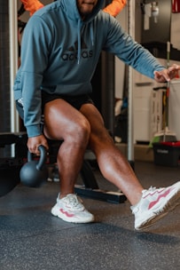 a man sitting on a bench in a gym