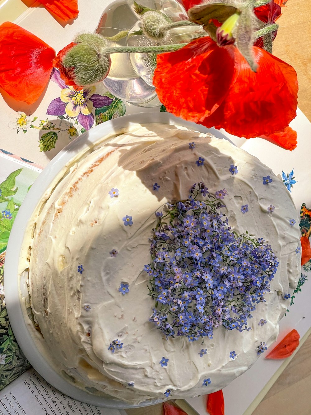 a cake with frosting and flowers on a plate