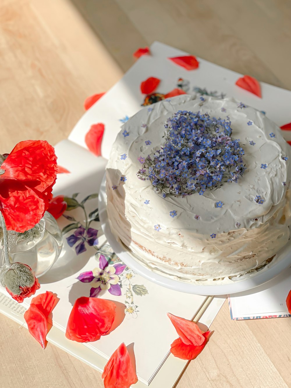 a cake with white frosting and blue flowers on a table