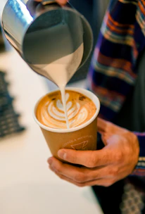A lively class session with students practicing latte art under instructor guidance.