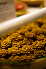 Close-up image of a luxurious pastry decorated with edible gold leaf and delicate pink rose petals.