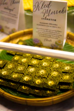 Close-up of a beautifully wrapped kalkatti paan with fresh green leaves and gold accents.