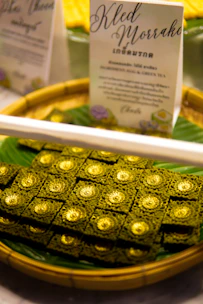 Close-up of a beautifully wrapped kalkatti paan with fresh green leaves and gold accents.