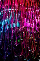 A close-up of fiber optic cables illuminated with colorful lights.