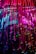 Colorful strands of fiber optic cables cascade downwards, illuminated in vibrant shades of pink, blue, and green. The strands are interspersed with small sparkling lights, creating a dazzling display of light and color.