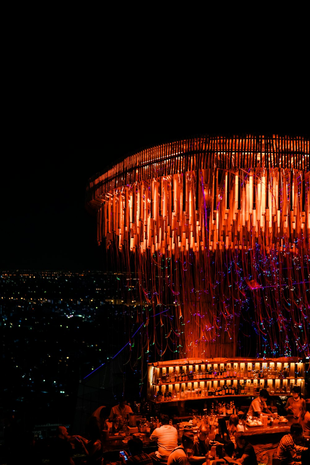 a group of people sitting at a table in front of a lit up structure