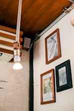 A serene gallery corner featuring framed mixed media artworks with soft lighting.