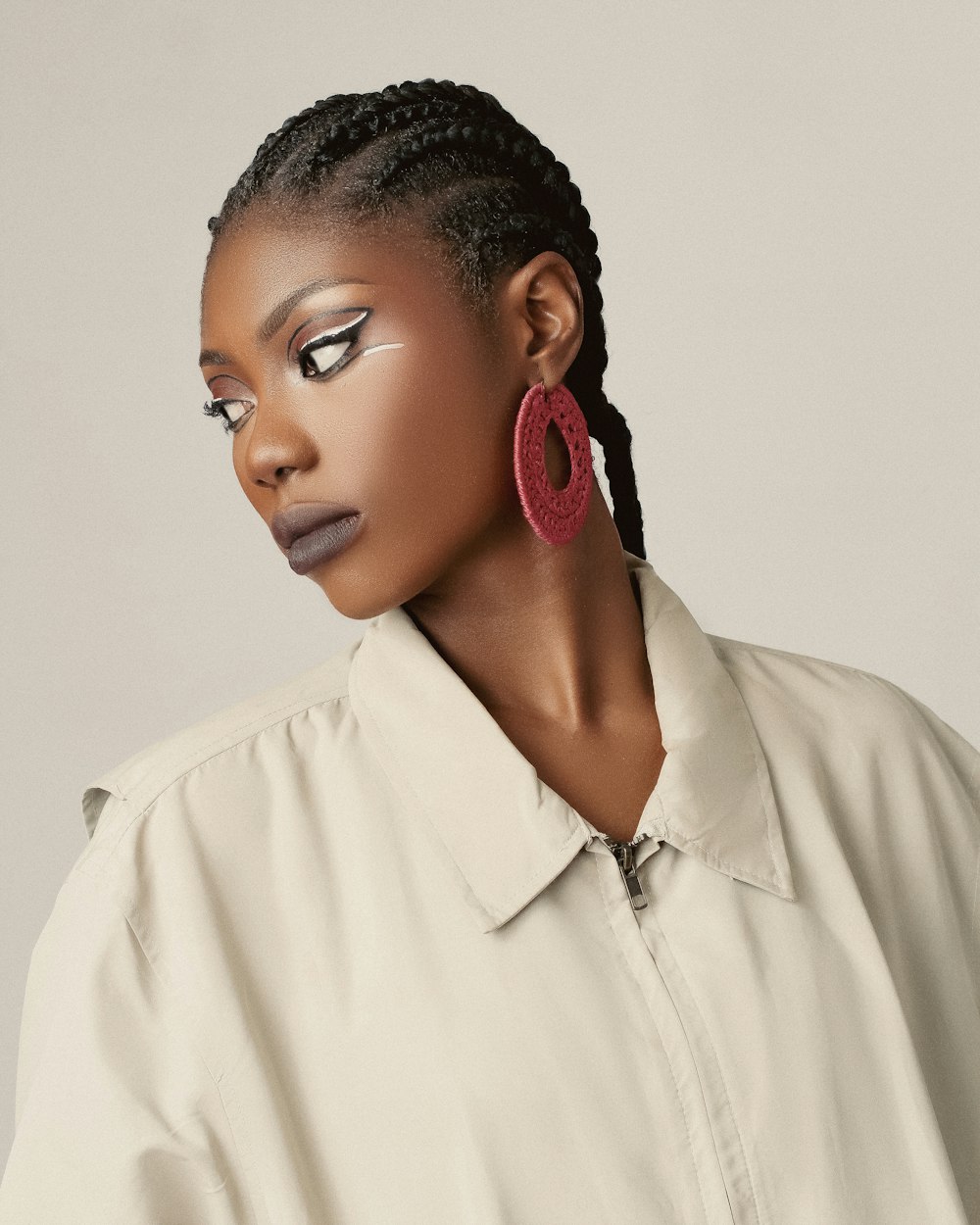 a woman wearing a white shirt and red earrings