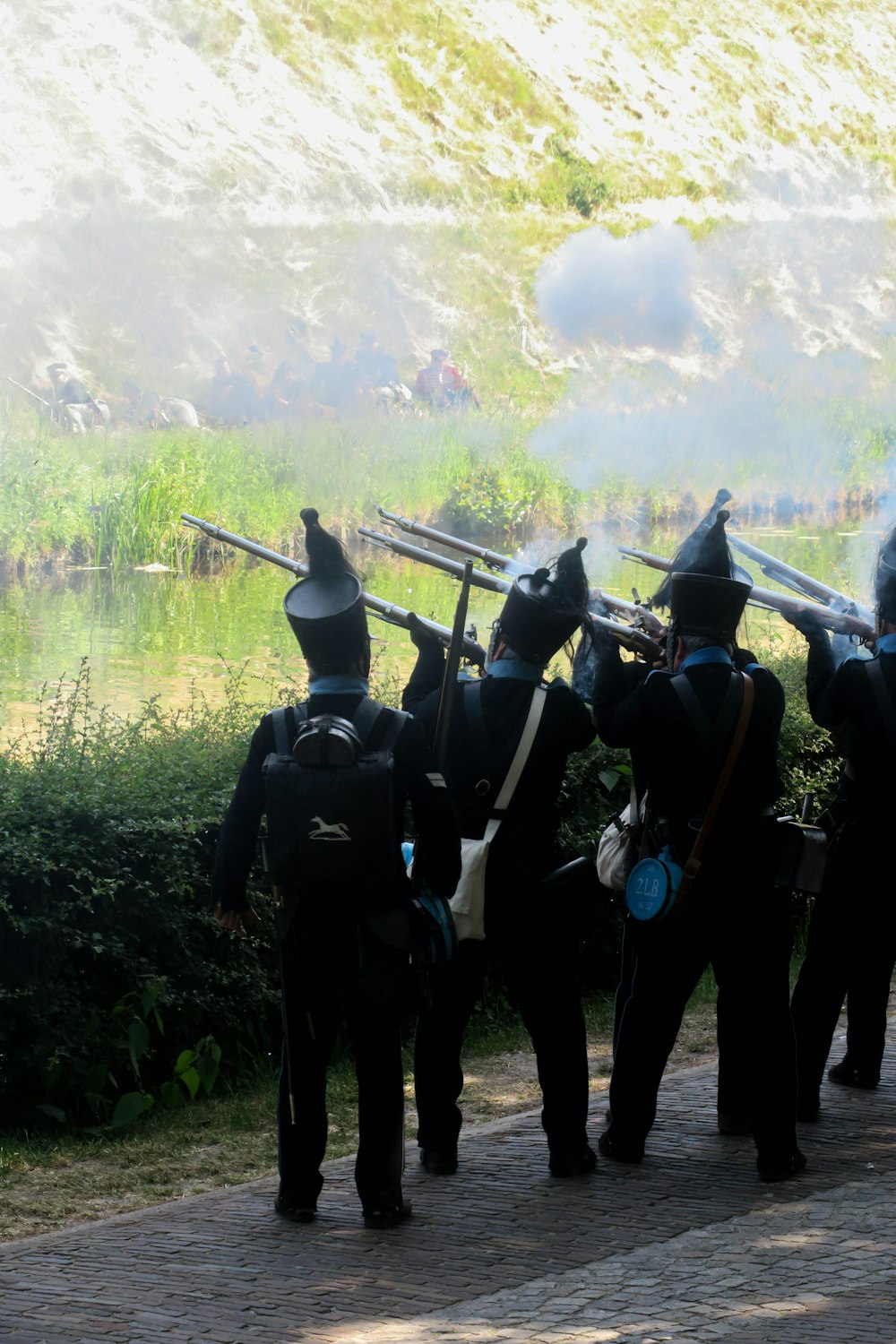 a group of men in black uniforms holding a long stick