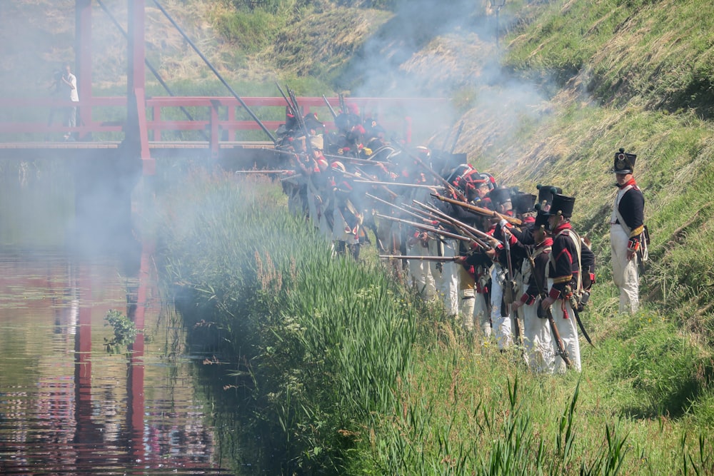 a group of men standing next to each other near a body of water