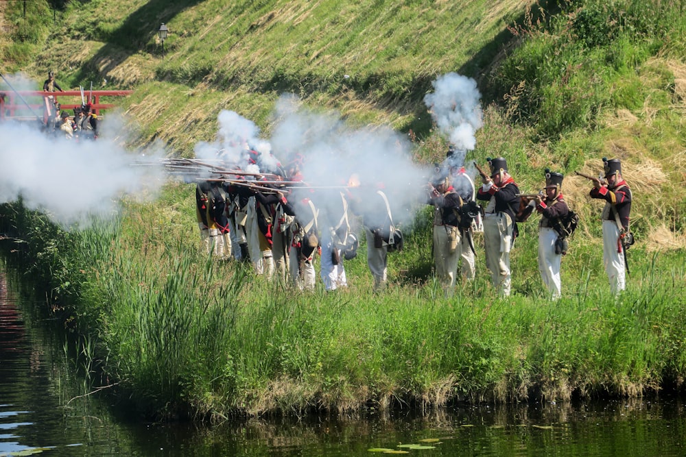 a group of men standing next to a body of water