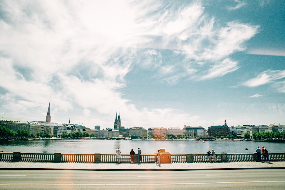 a group of people walking across a bridge over a river