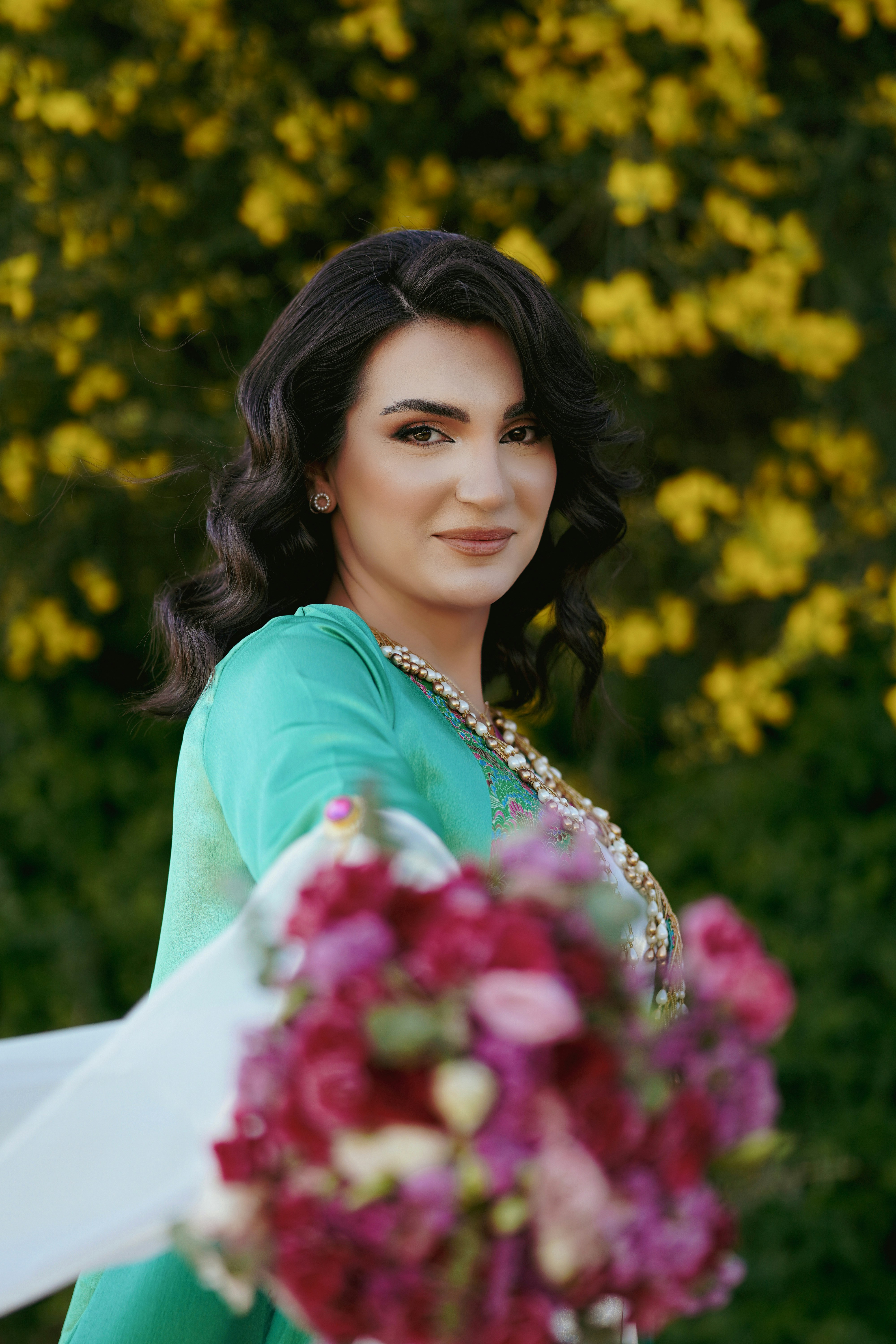 a woman in a green dress holding a bouquet of flowers