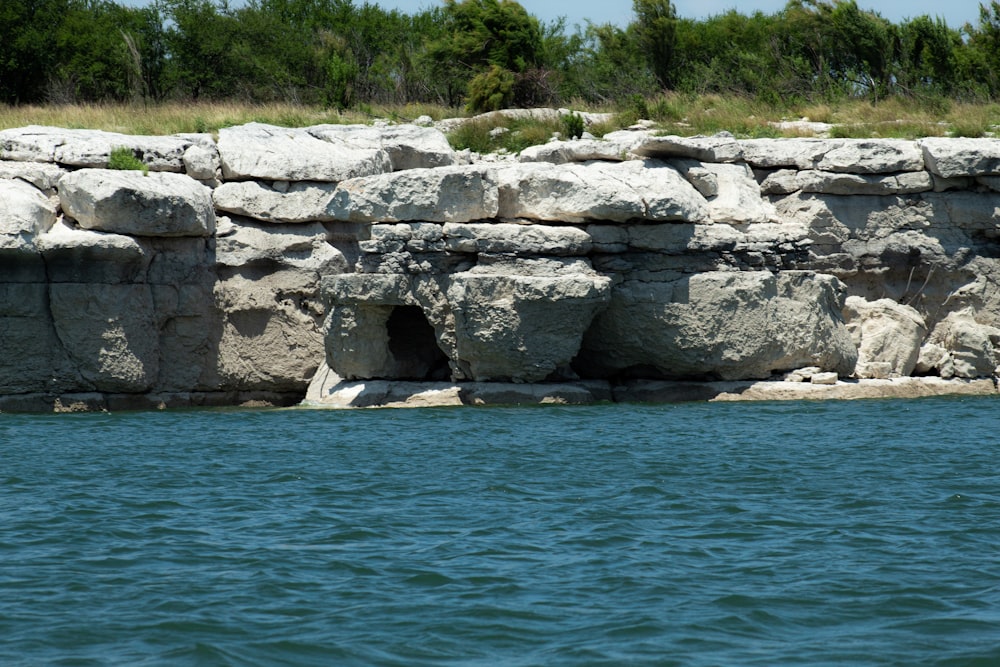 a large body of water next to a rocky cliff