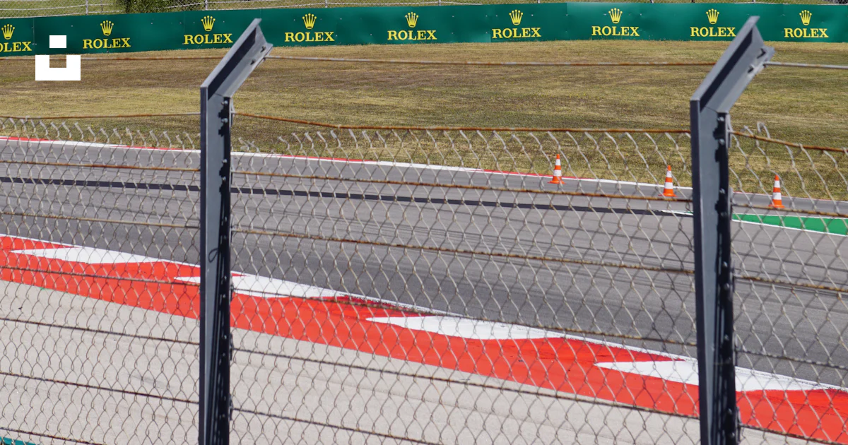 A race track with a large building in the background photo – Free ...