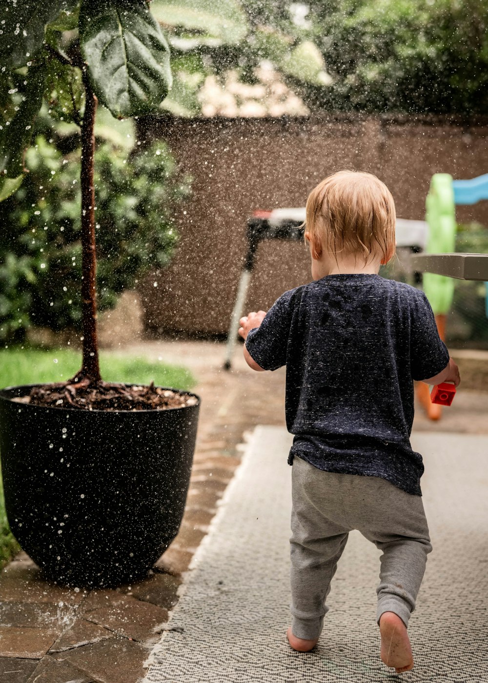 a little boy that is standing in the rain