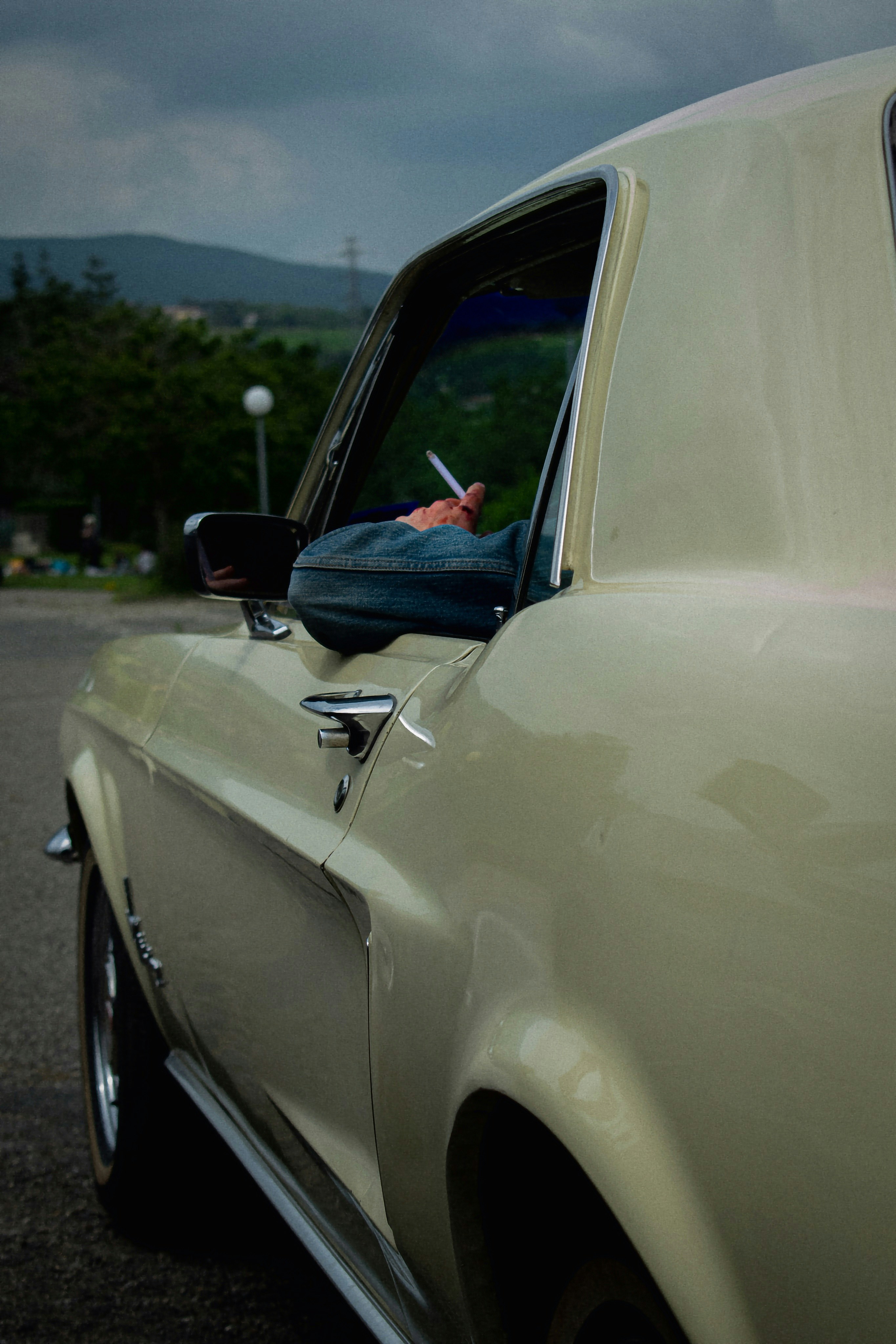 a man sitting in a car smoking a cigarette