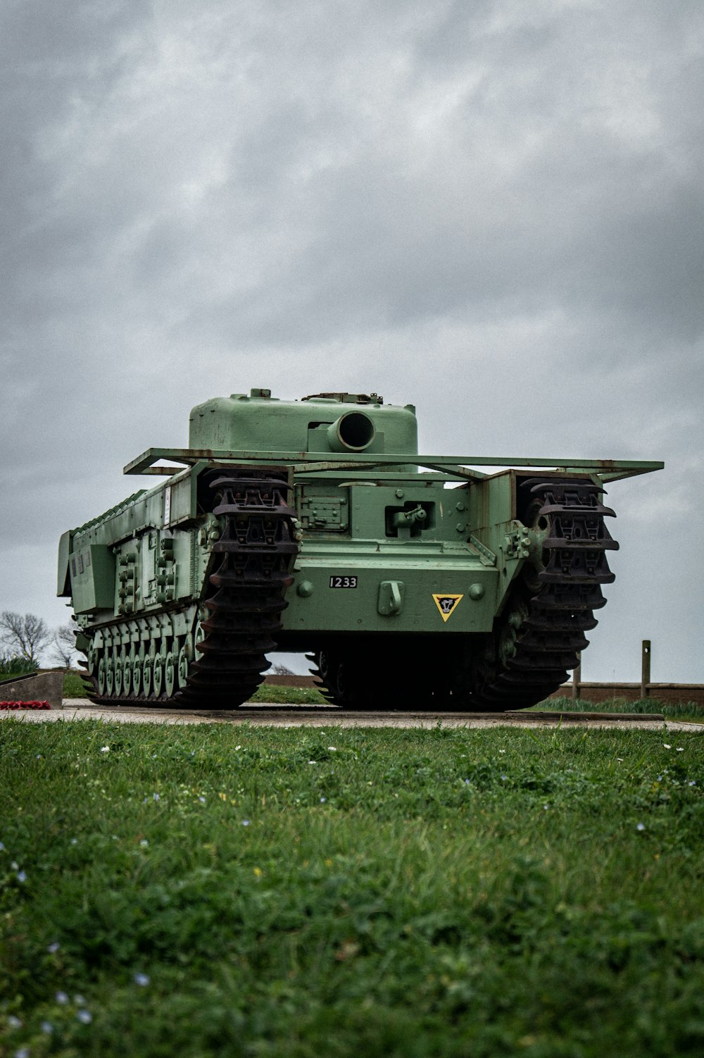 Ein großer grüner Panzer, der auf einem üppig grünen Feld sitzt