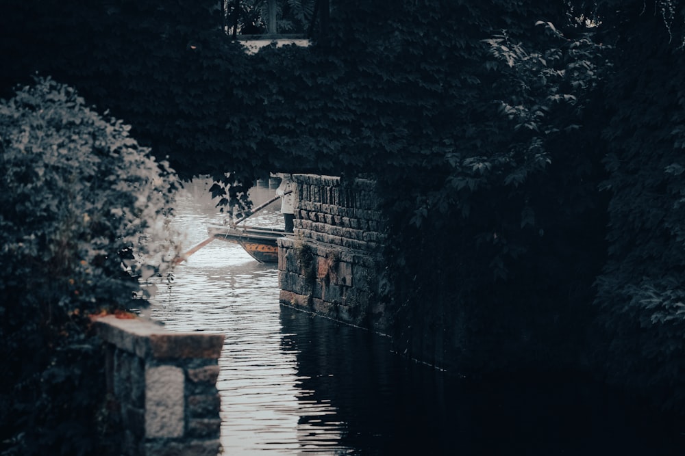 a narrow canal with a bridge in the background