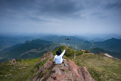 A behind-the-scenes photo of David Padilla operating a drone in a dramatic mountain landscape.
