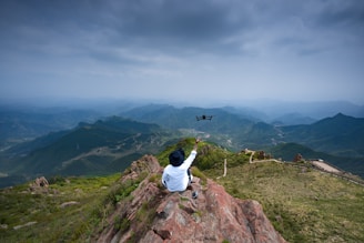 A behind-the-scenes photo of David Padilla operating a drone in a dramatic mountain landscape.