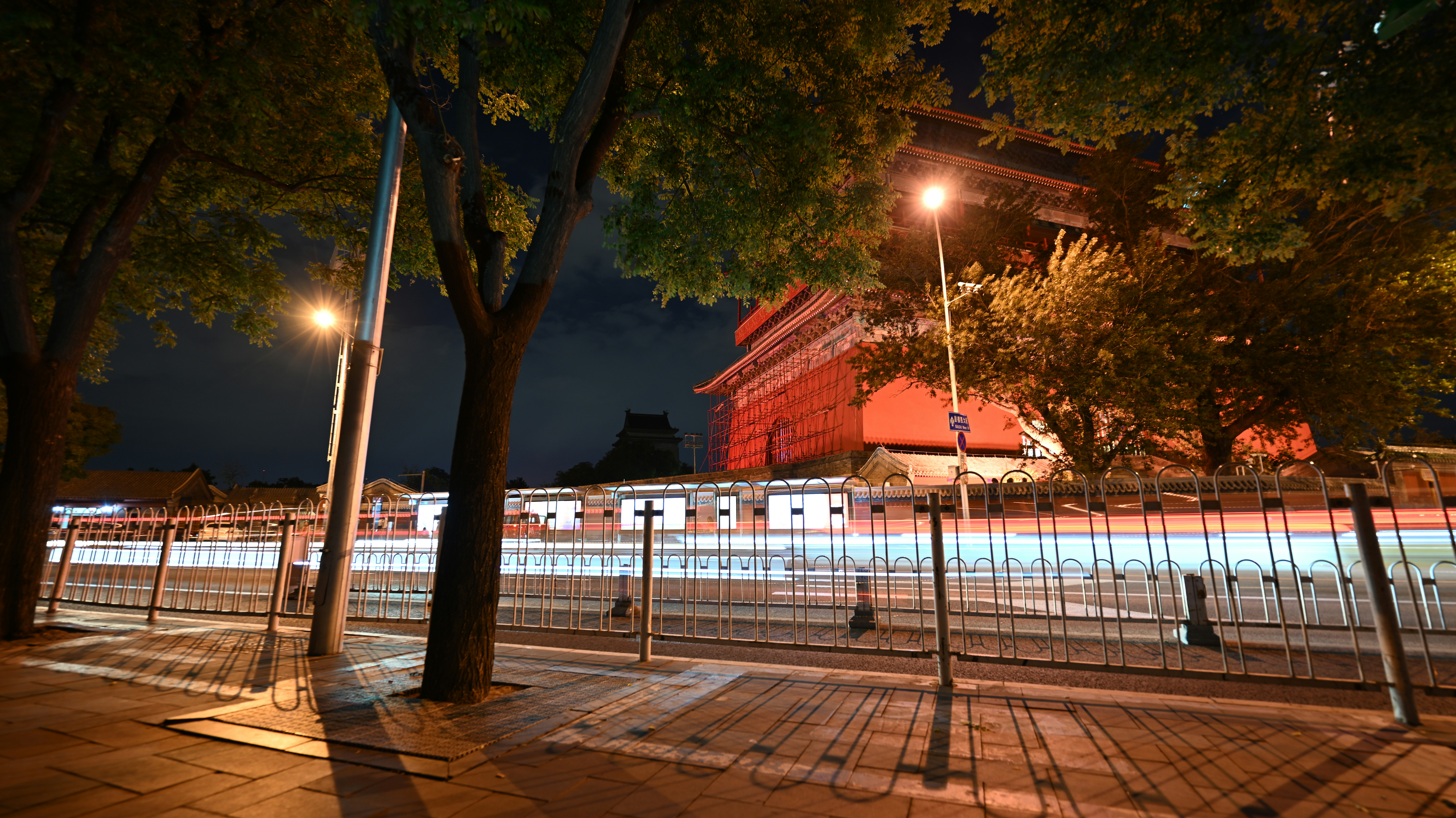 a night view of a city street with a building in the background