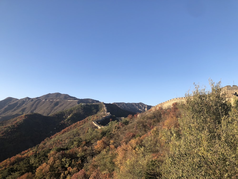 a view of the great wall of china from the top of a hill